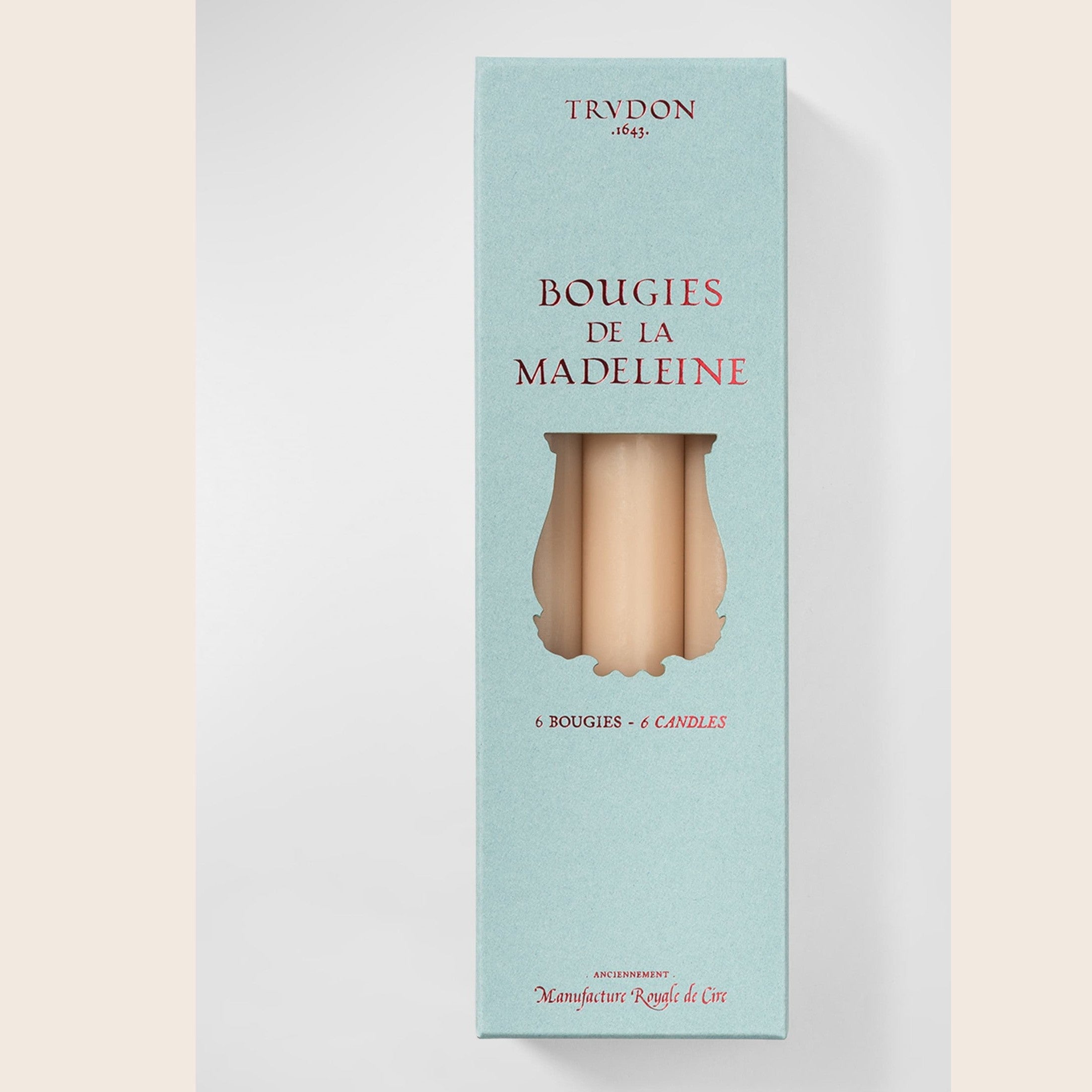 Six Trudon Madeleine taper candles in aqua, arranged in a box, featuring elegant, slender candle design for decorative lighting.